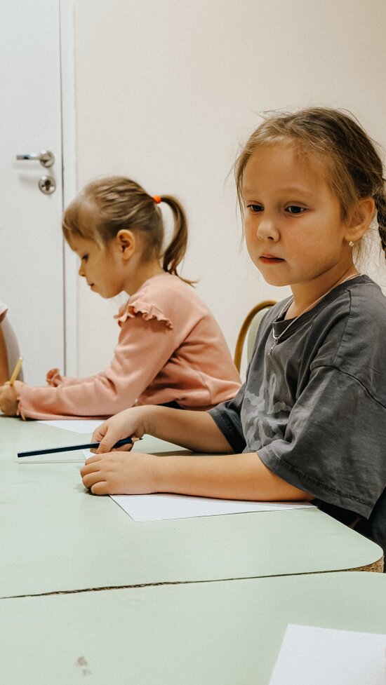 Elevi care rezolvă exerciții de matematică la tablă interactivă